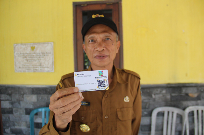 Kepala Desa Sidokerto, Abdul Halim menunjukkan kartu iuran pembayaran yang dibuat Pemdes Sidokerto, untuk warganya