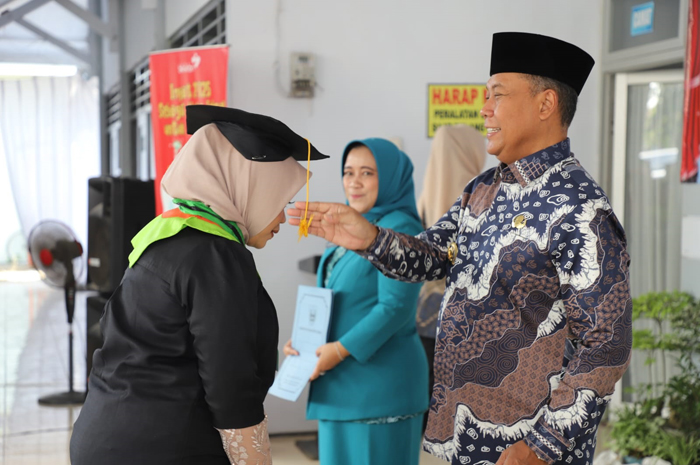 Pj Bupati Jombang, Sugiat memindahkan tali toga wisudawati Sekolah Orang Tua Hebat (SOTH) di Pendopo Kecamatan Megaluh, Kamis (27/6).