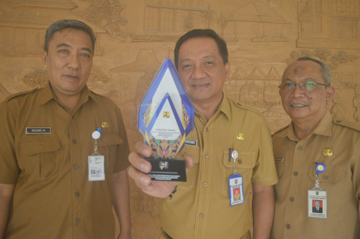 Sekdakab Jombang, Agus Purnomo, bersama Asisten Perekonomian dan Pembangunan Setdakab, Wignyo Handoko, serta Kepala Dinas Perkim Agung Hariadi menunjukkan trofi penghargaan, Senin (1/7).