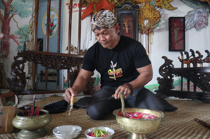 Yudi Rianto pemilik jasa cuci keris di Desa Mojotengah, Kecamatan Bareng. saat menjamas pusaka di rumahnya, Jumat (5/7).