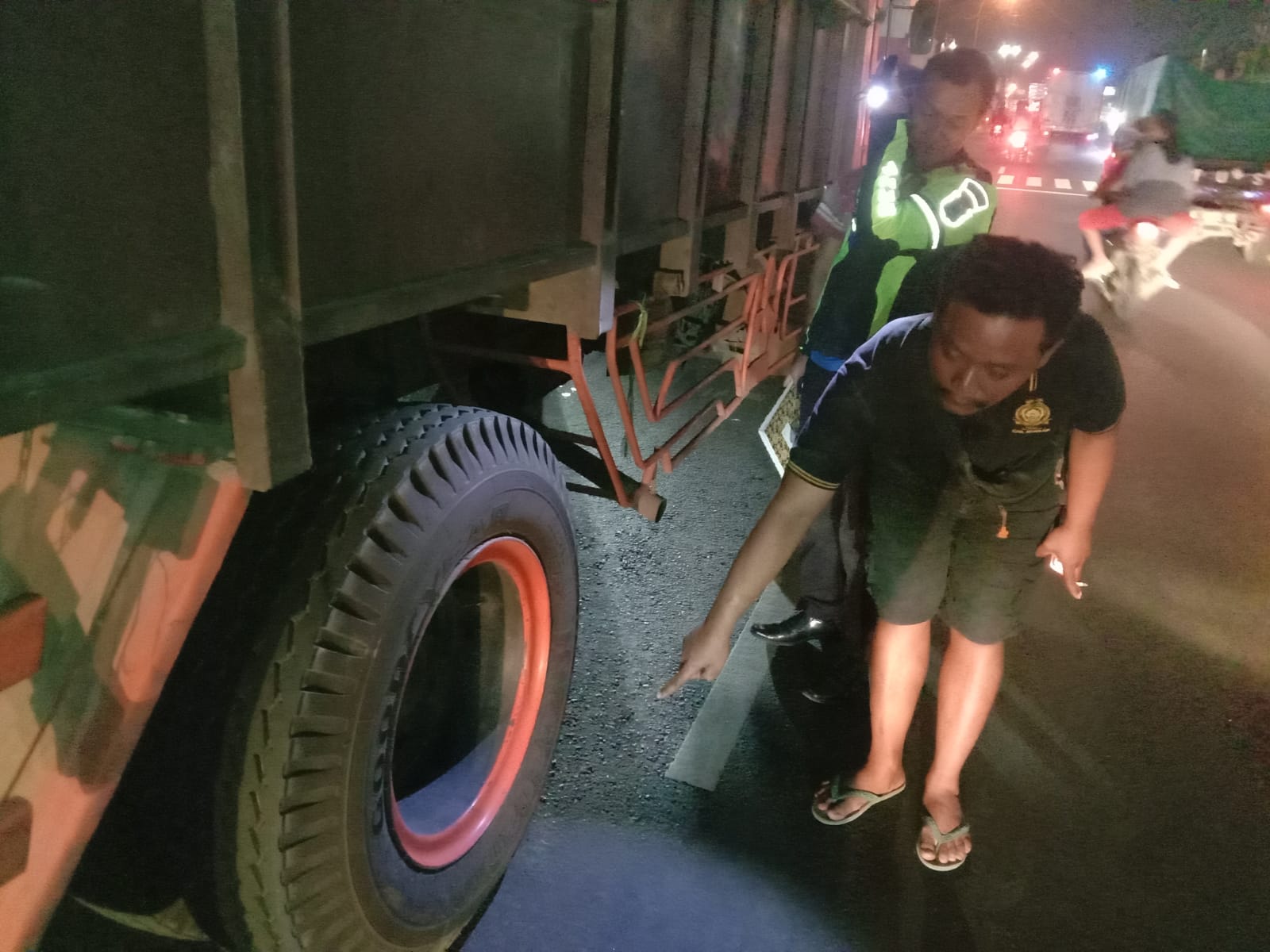 Petugas kepolisian saat melakukan olah kejadian perkara jukir yang terlindas truk gandeng di Mojoagung Jombang