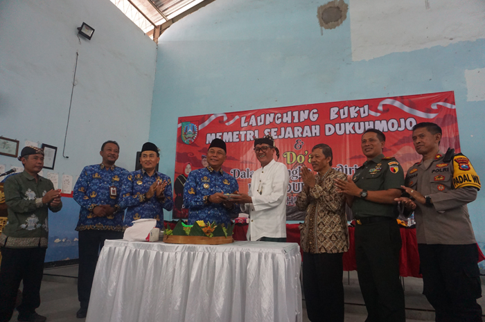 Kades Dukuhmojo Nur Aini Ruba&rsquo;i  foto bersama Pj Bupati Jombang Sugiat dan Cak Nas dalam peluncuran buku Memetri Sejarah Dukuhmojo, Rabu (17/7).