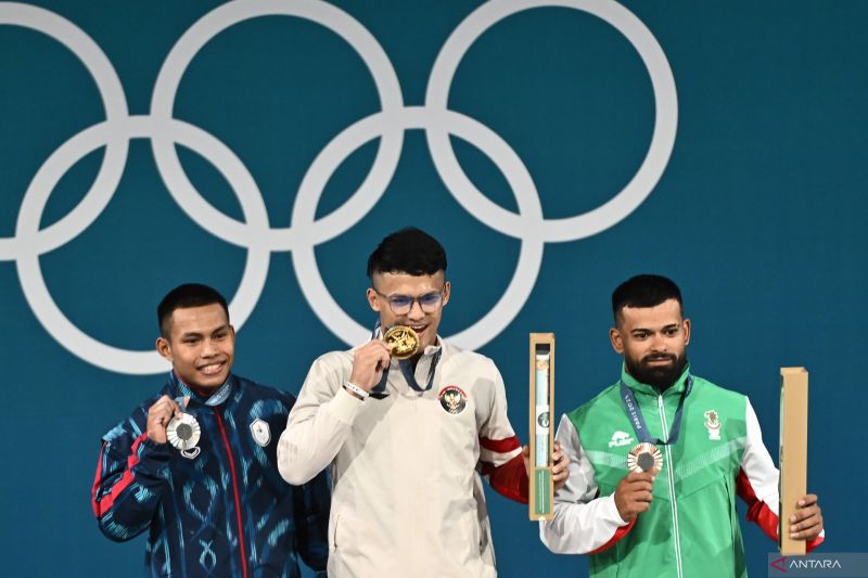 Lifter Indonesia Rizki Juniansyah (tengah) bersama lifter Thailand Wichuma Weeraphon (kiri) dan lifter Bulgaria Andreev Bozhidar Dimitrov (kanan) berpose dengan medali mereka