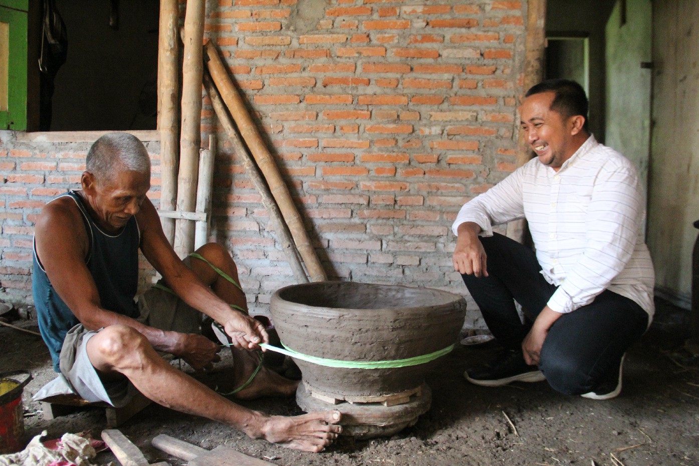 Kepala Desa Mojotrisno Nanang Sugiarto saat mengunjungi Tiyamun, 75, warga Dusun Sanan Timur, Desa Mojotrisno, Kecamatan Mojoagung perajin Gentong Majapahitan.