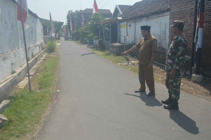 TUNTAS: Kades Ngudirejo Lantarno menunjukkan jalan antar RT yang selesai diperbaiki di Dusun/Desa Ngudirejo, Kecamatan Diwek, Jombang.