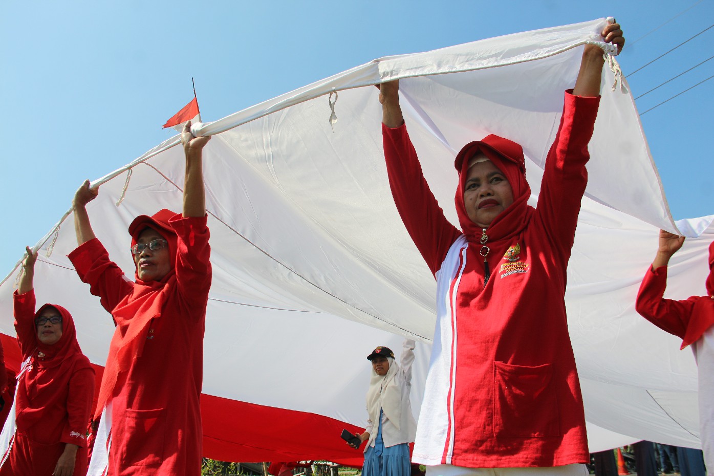Ratusan warga Desa Ngudirejo, Kecamatan Diwek saat mengirab bendera raksasa ukuran 10x15 meter, Sabtu (17/8).