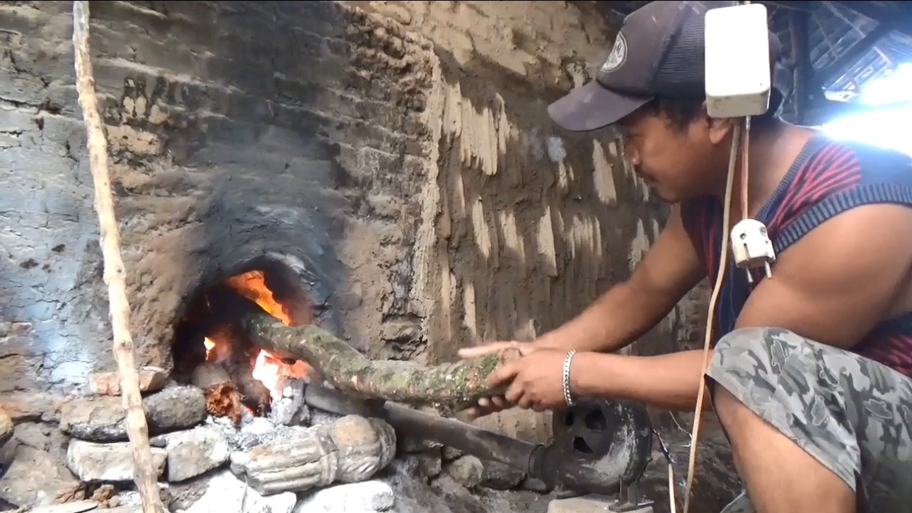 Rusmanto sedang memproduksi arang di rumahnya