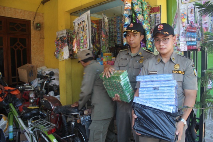 Petugas Satpol PP Jombang saat menyita sejumlah rokok ilegal dalam razia di sebuah warung di Jombang