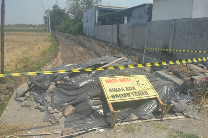 DIBERSIHKAN: Pembersihan limbah B3 di Jalan Usaha Tani (JUT) Desa Madiopuro, Kecamatan Sumobito.