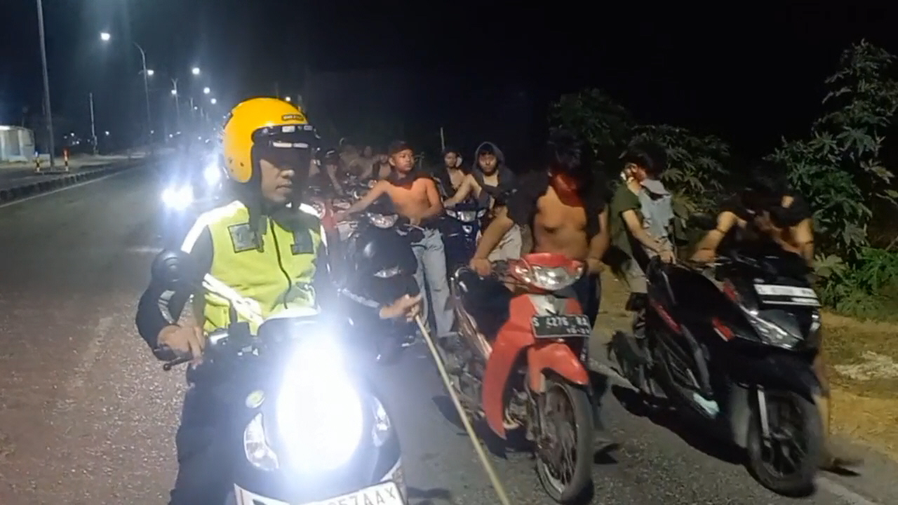 Puluhan pembalap liar di ringroad Mojoagung digiring jalan kaki menuntun motor menuju Polsek Mojoagung