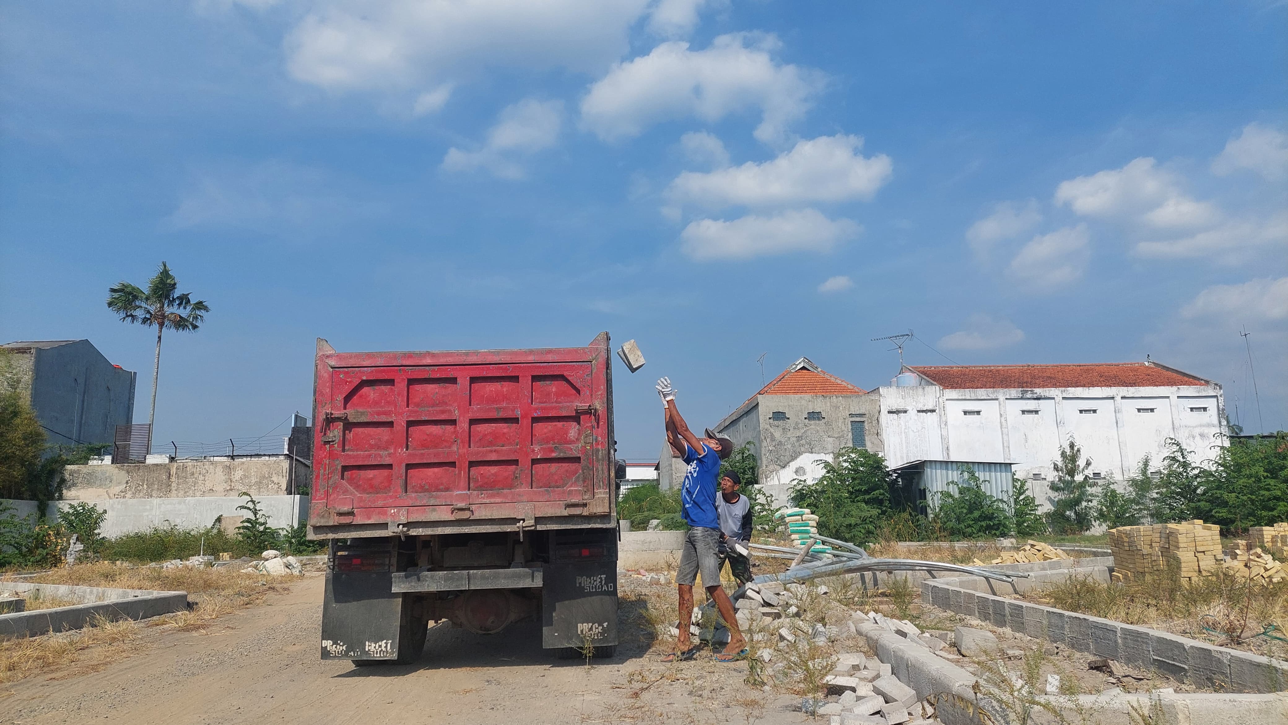 Beberapa pekerja mengambil kembali paving dari loaksi proyek sentra PKL Ahmad Dahlan Jombang yang telah diputus kontrak sebelumnya