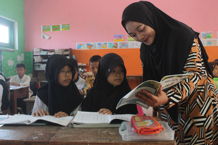 Nabilah, guru SDN Spanyul Kecamatan Gudo ketika mengajar pendidikan diniyah kelas 4 SD menggunakan kitab.