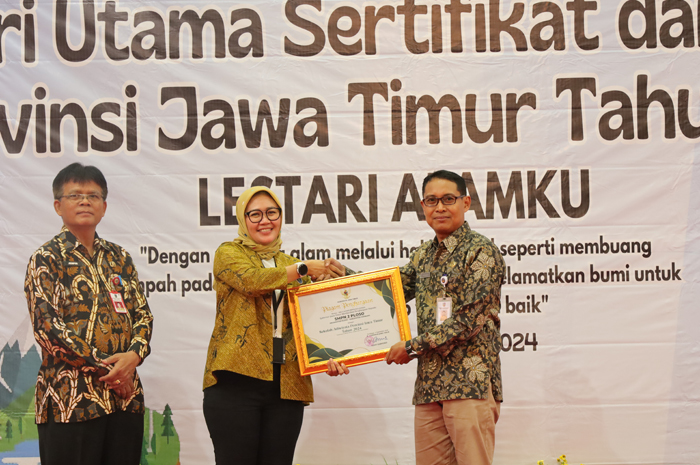 Kepala SMPN 2 Ploso, Winarko MPd, saat menerima piagam penghargaan sekolah Adiwiyata dari Kepala Dinas Lingkungan Hidup (DLH) Provinsi Jawa Timur, Jempin Marsun di Gedung Graha Wisata Surabaya