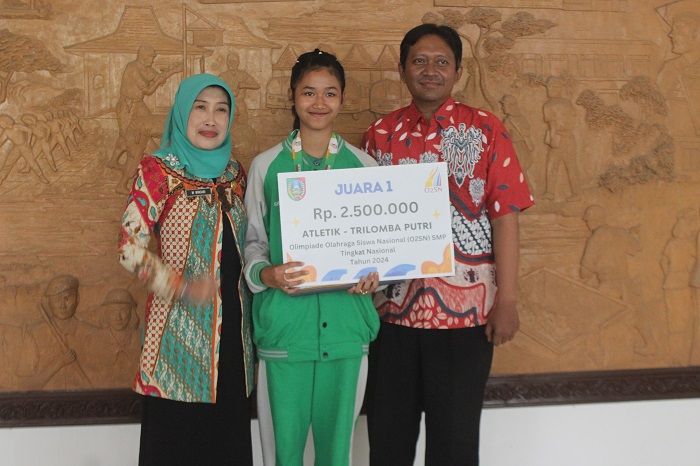 Kepala SMPK YBPK Mojowarno, Tri Yugo Wicaksono bersama Kepala Dinas P dan K, Wor Windari, meberikan apresiasi kepada Shelly Septi Andhani.