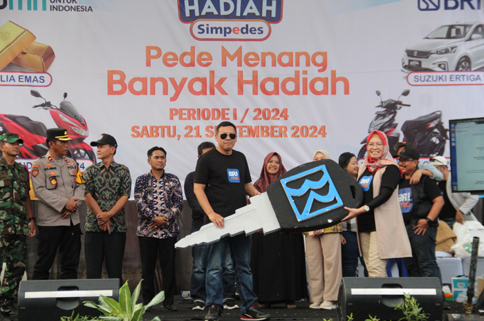 Penyerahan secara simbolis mock up kunci mobil Suzuki New Ertiga kepada pemenang hadiah grand prize yang diwakiliki kepala unit pemenang.