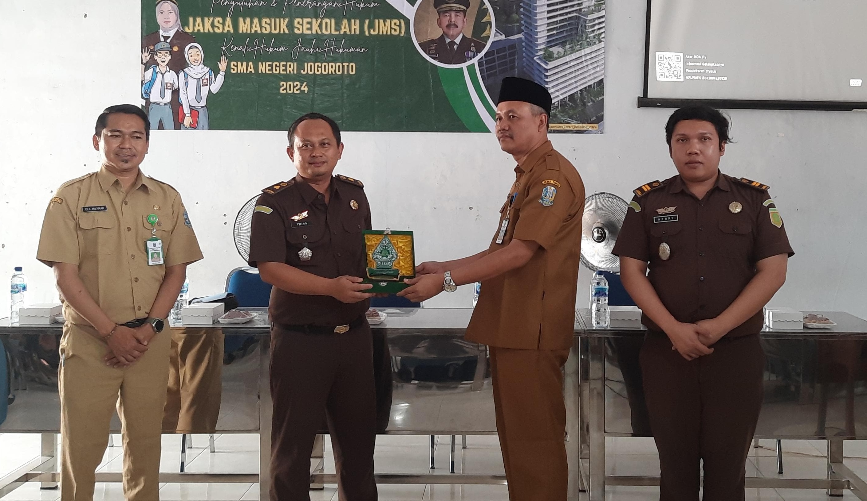 Penyerahan cinderamata dari Kasi Intelijen Kejaksaan Negeri Jombang, Dr Trian Yuli Diarsa SH MH, kepada Kepala SMAN Jogoroto, Mualim.