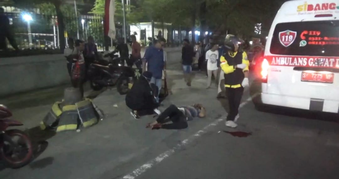 Kondisi pemotor yang terkapar usai motornya menyenggol gerobak bakso di depan Stasiun Jombang