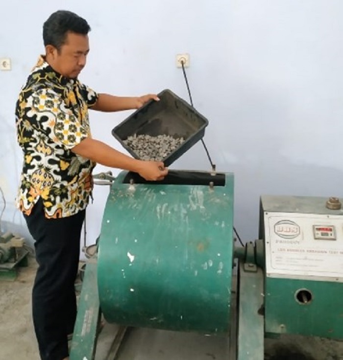 Petugas menunjukkan produksi aspal dingin secara mandiri milik Dinas PUPR Jombang