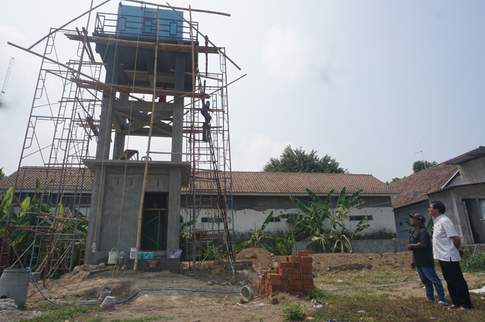 Kepala Desa Krembangan Kusnan (kemeja putih) menunjukkan lokasi tempat penampungan air yang berada di TKD Krembangan.