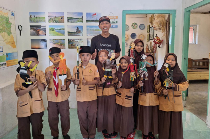 Koordinator Pengelola Museum Brantas, Lahir Jaka mengenalkan wayang Brantas kepada anak-anak.