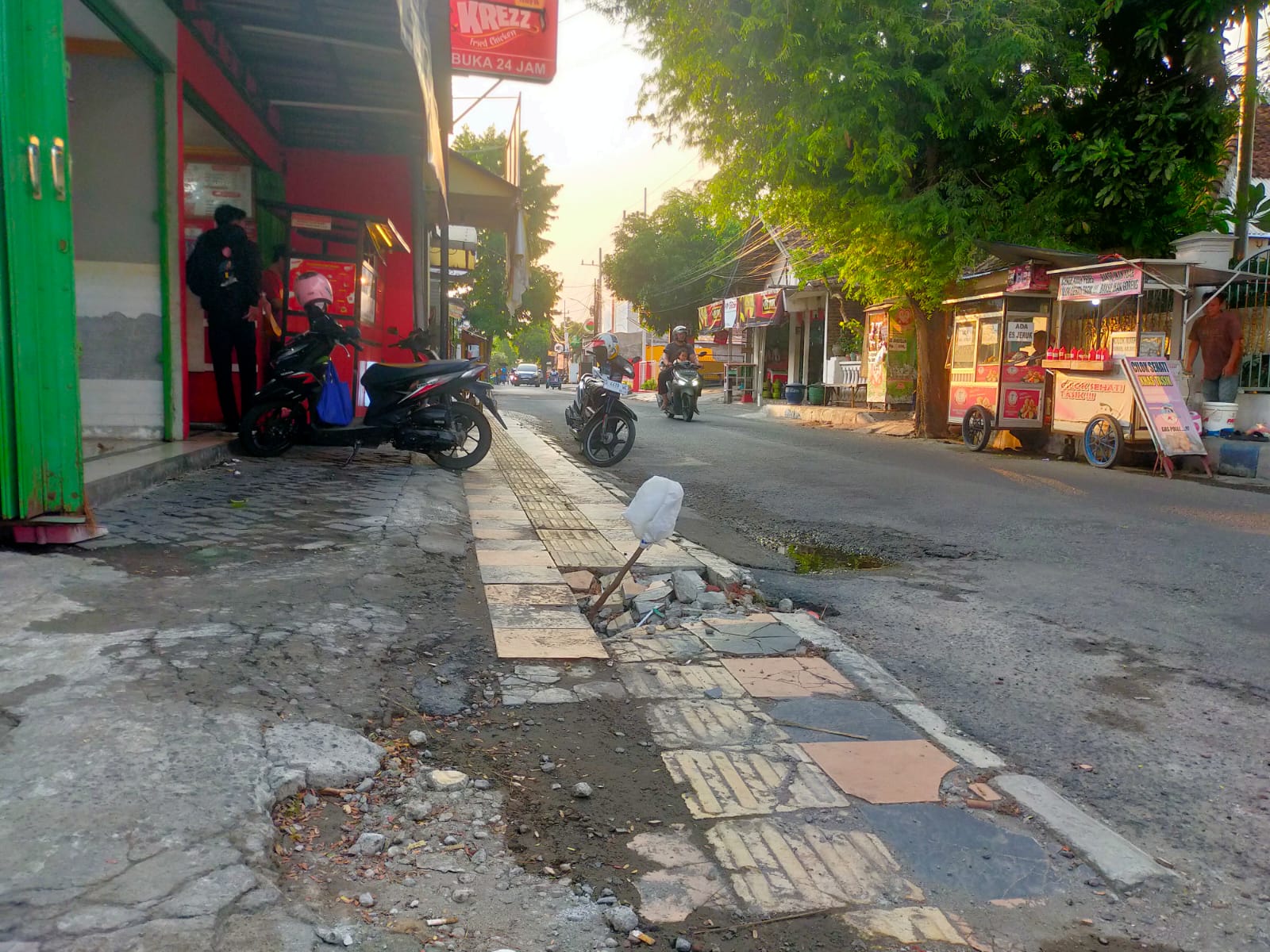 Kondisi trotoar Jl Gubernur Suryo Jombang yang jebol dan ditandai kayu