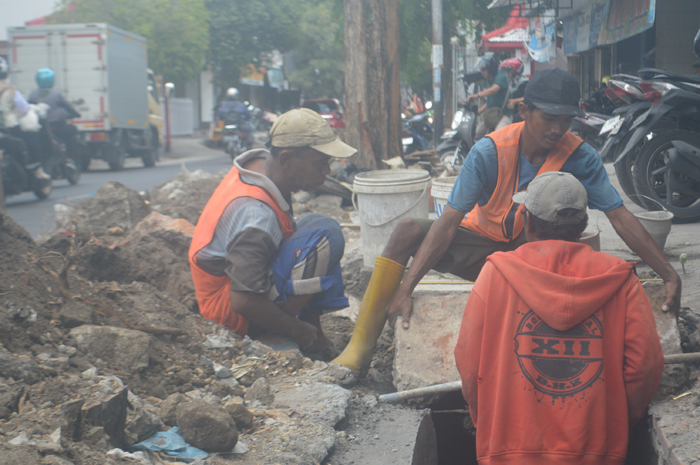 Proses pengerukan drainase di Jl RE Martadinata, Kepatihan, Jombang yang jadi langganan banjir