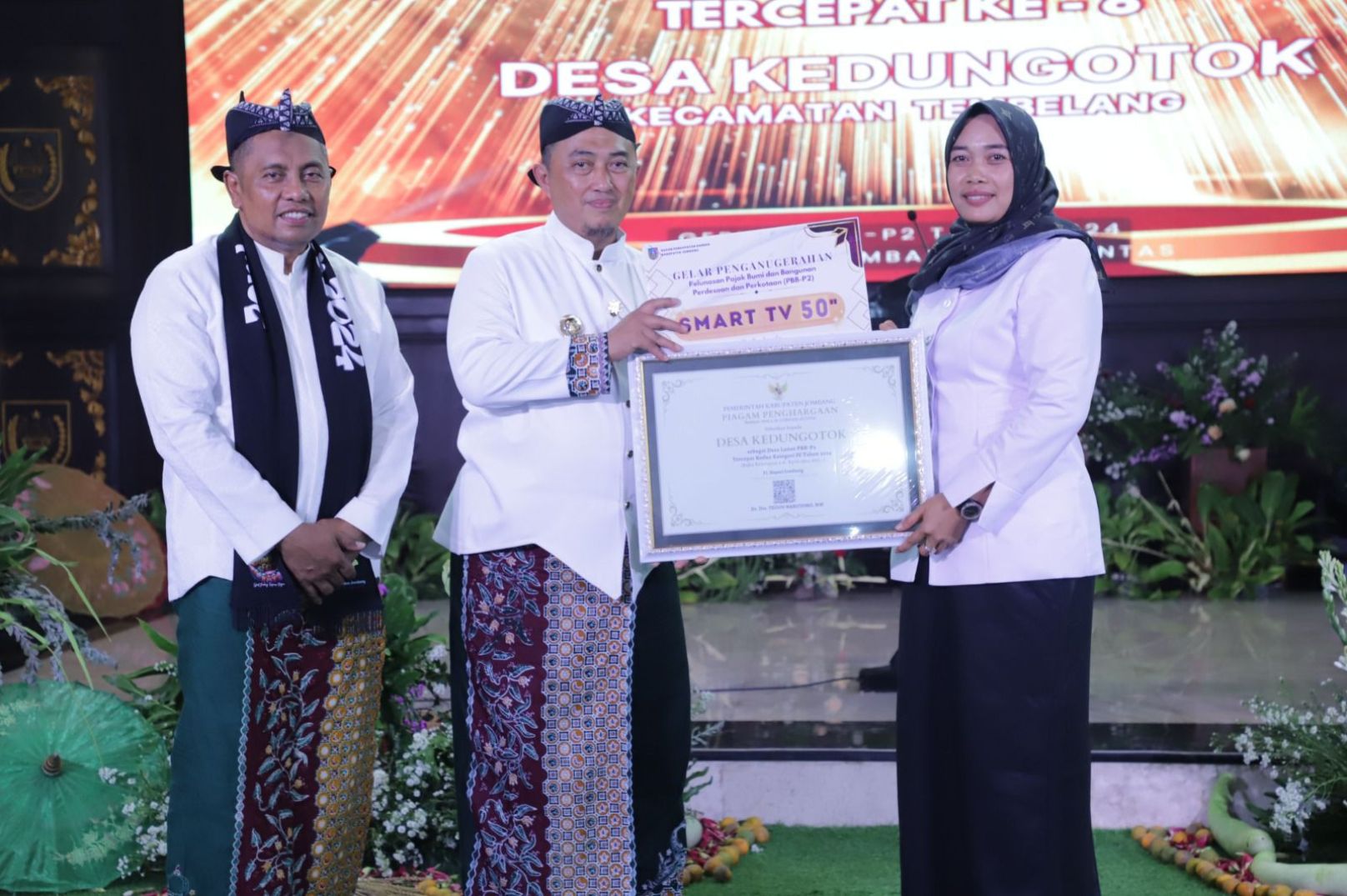 Kepala Desa Kedungotok Sulistyowati menerima penghargaan dari Pj Bupati Jombang Teguh Narutomo terkait pelunasan PBB-P2 2024.