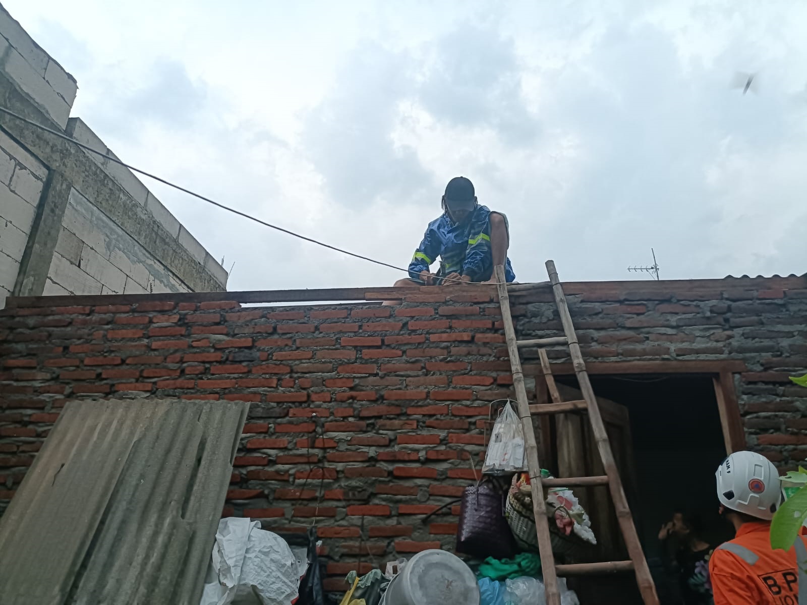 Warga di Jombang membanhi atap rumah mereka yang rusak diterjang angin kencang