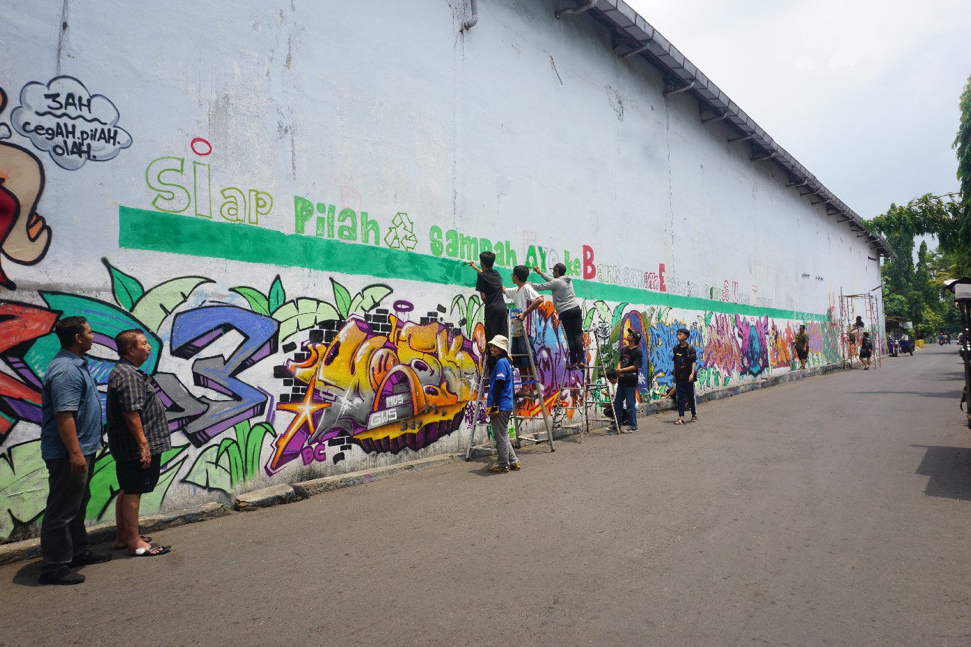 Kepala Kelurahan Kaliwungu Ade Yudha Kusuma bersama Ketua RT 05 Kaliwungu Tjandra Iewanto menyaksikan proses mural oleh kader lingkungan berkolaborasi dengan Komunitas Sanggar Hijau Indonesia