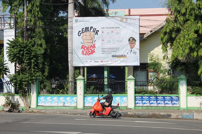 SOSIALISASI: Sebuah reklame terkait ciri ciri rokok ilegal di pasang di Jl Cempaka Jombang.