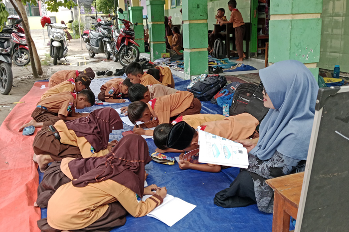 DARURAT: Siswa SDN Jarak 2, Jogoroto, Jombang belajar di halaman sekolah selama proses rehab sekolah belum selesai.