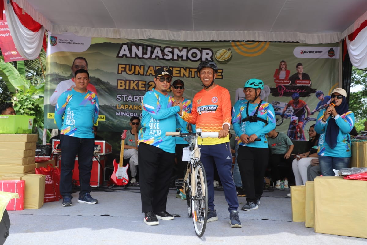 Pj Bupati Jombang Teguh Narutomo didampingi Kepala Dinas Kepemudaan Olahraga dan Pariwisata Bambang Nurwijanto saat menyerahkan hadiah kepada peserta, Minggu (8/12).