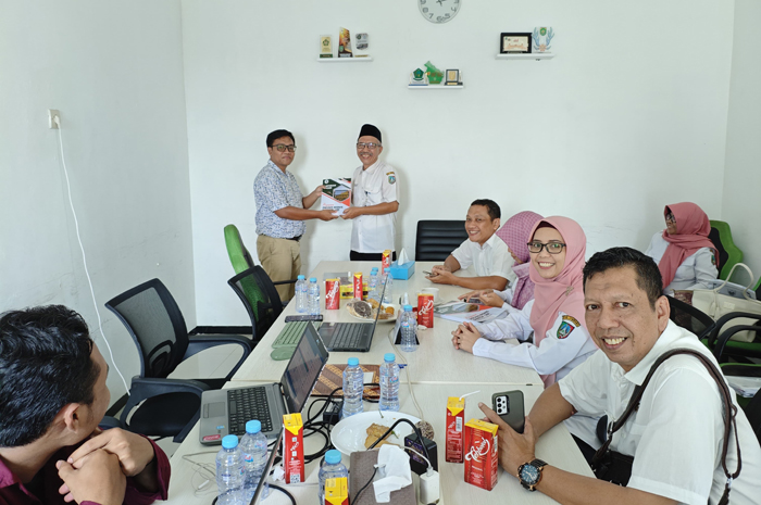 Ali Maskur tenaga ahli smart.id, menyerahkan laporan akhir proses bisnis kepada Sekretaris Dinkop UM, Gatut Wijaya.