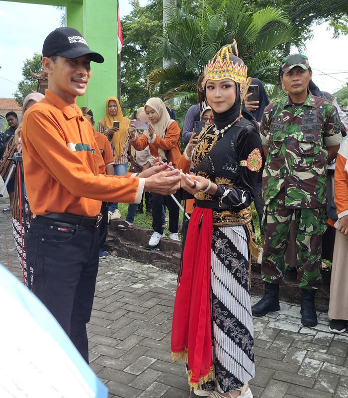 Kepala SMPN 1 Jombang, Rudy Priyo Utomo, menyerahkan busur panah untuk pemberangkatan peserta pawai budaya