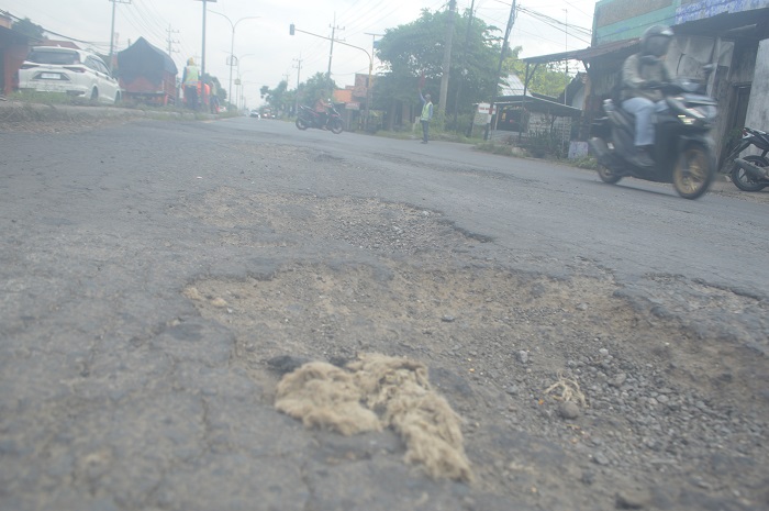 ANCAM PENGENDARA: Lubang menganga di jalan raya Mojoagung yang belum dilakukan perbaikan.