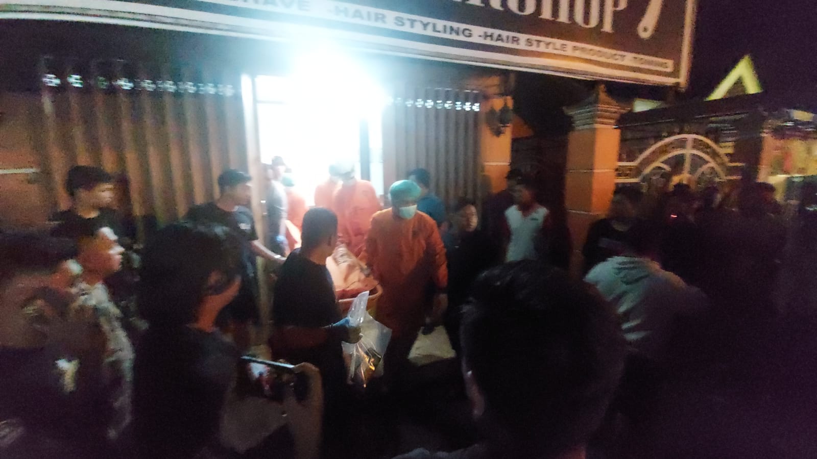 Petugas saat mengevakuasi jasad korban lembunuhan dari dalam barbershop di Jombang