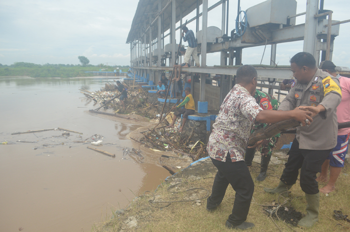 BERJIBAKU: Warga bersama petugas melakukan pembersihan sangkrah di pintu Dam Yani di Desa Budugsidorejo, Kecamatan Sumobito yang tak fungsi, Kamis (23/1).