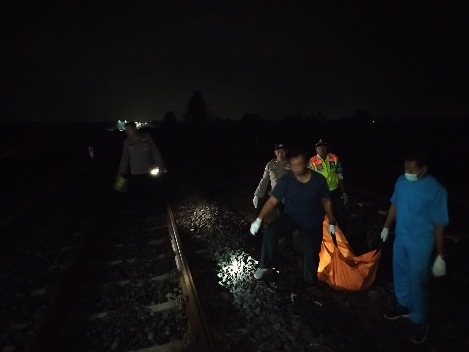 Proses evakuasi jasad pria yang menabrakkan diri ke kereta api di Sumobito, Jombang
