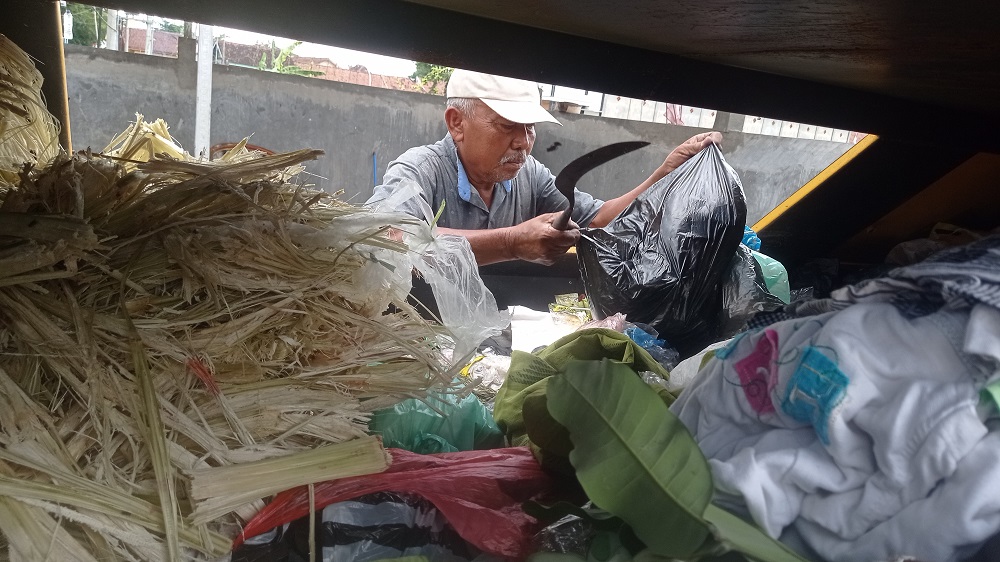 Salah seorang warga membuang sampah di TPS (tempat penampungan sementara) Desa Tunggorono, Kecamatan Jombang.