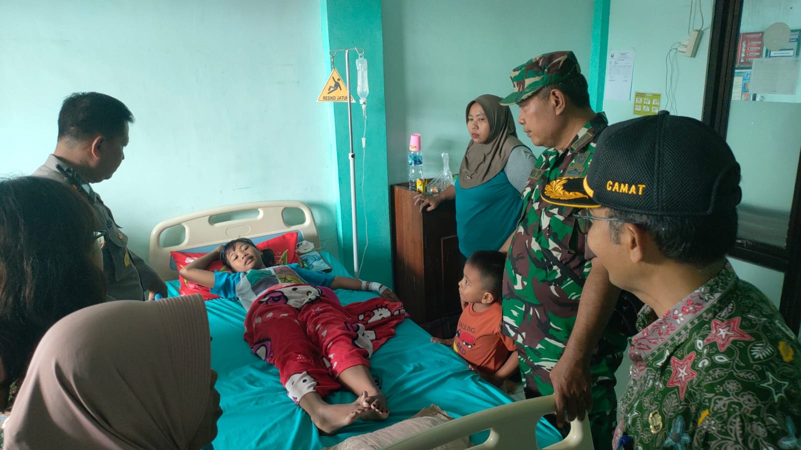 Polisi saat menjenguk salah satu siswa SDN Wuluh 1 Kecamatan Kesamben yang keracunan dan dirawat di Puskesmas Kesamben, Rabu (19/1).