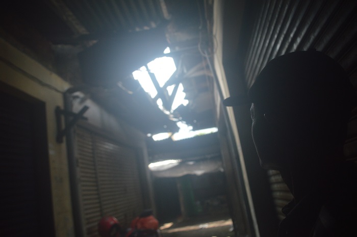 RUSAK: Salah seorang pedagang menunjukkan atap dan talang air Pasar Peterongan yang rusak, Senin (24/2).