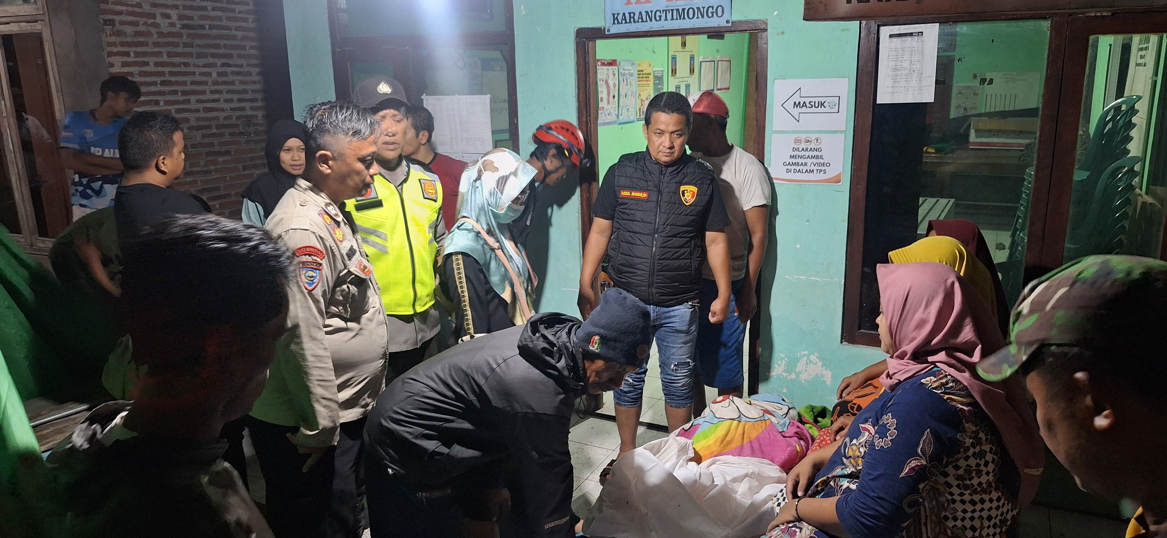 Petugas kepolisian dan kesehatan saat melakukan pemeriksaan pada jasad lansia sebatangkara yang ditemukan tewas di saluran air Desa Denanyar Jombang