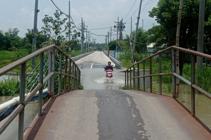 Kondisi Kali Marmoyo di Desa Jatigedong, Ploso, Jombang yang penuh dan airnya meluber hingga ke jalan