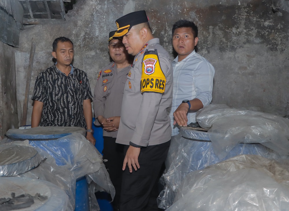 Polisi saat melakukan penggerebekan pada pabrik miras jenis arak putih di Jombok, Ngoro, Jombang