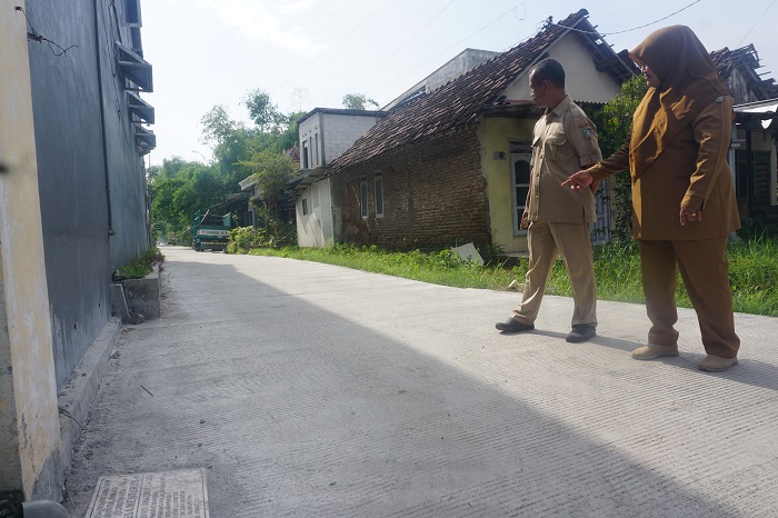 SEMAKIN BERKEMBANG: Kepala Desa Menturus Nyamiati didampingi perangkat saat menunjukkan salah satu lokasi pembangunan jalan rabat beton di Dusun/Desa Menturus