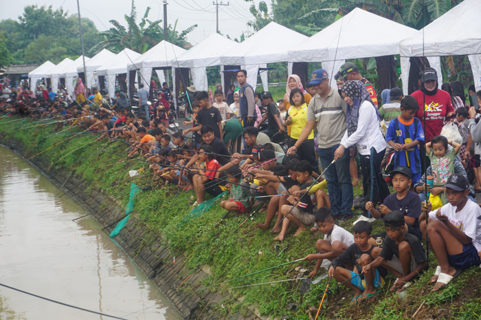 Kepala Desa Tanggalrejo Dimas Wahyu Ramadhana didampingi istri dan Babinkamtibnas membaur bersasma masyarakat saat acara mancing bersama di grand opening car free day Desa Tanggalrejo.
