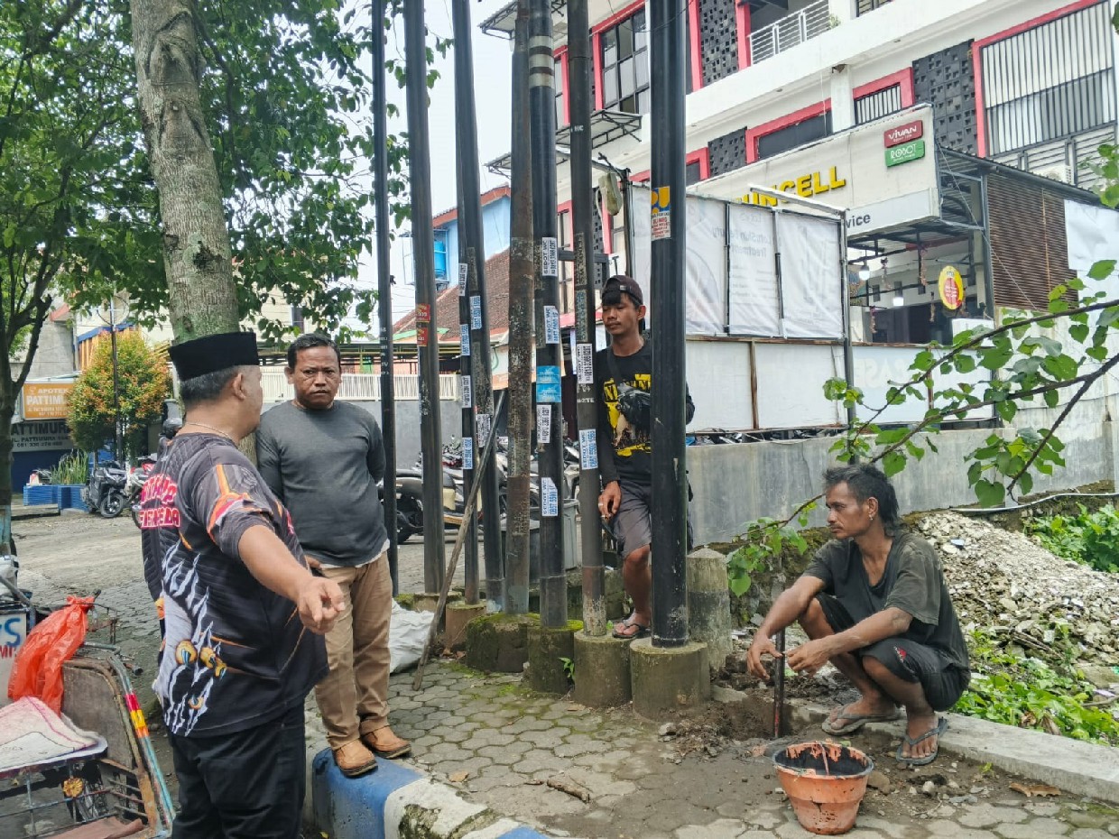 Satpol PP Jombang menghentikan pemasangan tiang fiber optik di Jalan Patimura, Desa Sengon, Kecamatan Jombang,  Jumat (14/3)