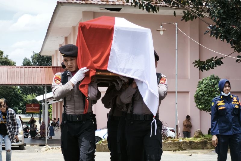 Personel kepolisian sedang mengangkut jenazah anggota polri yang meninggal dunia saat melakukan penggerebekan judi sabung ayam di Kabupaten Waykanan. Lampung, Selasa (18/3/2025).