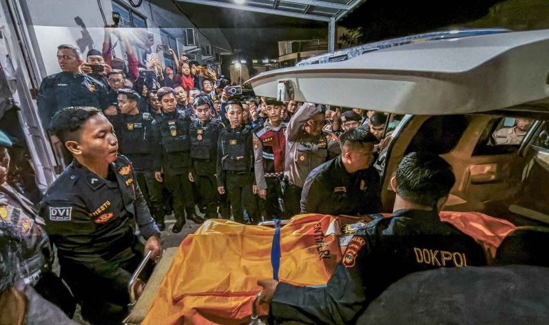 Petugas menurunkan jenazah anggota Polri yang tewas tertembak saat melakukan penggerebekan judi sabung ayam, setibanya di RS Bhayangkara Polda Lampung, Lampung, Selasa (18/3/2025).