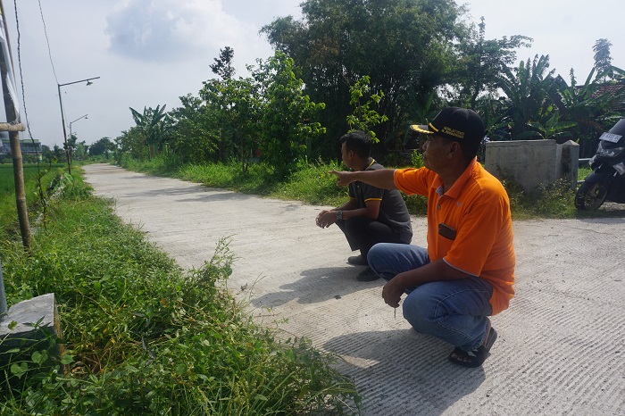 Perangkat desa Pandanwangi menunjukkan lokasi pembangunan jalan cor